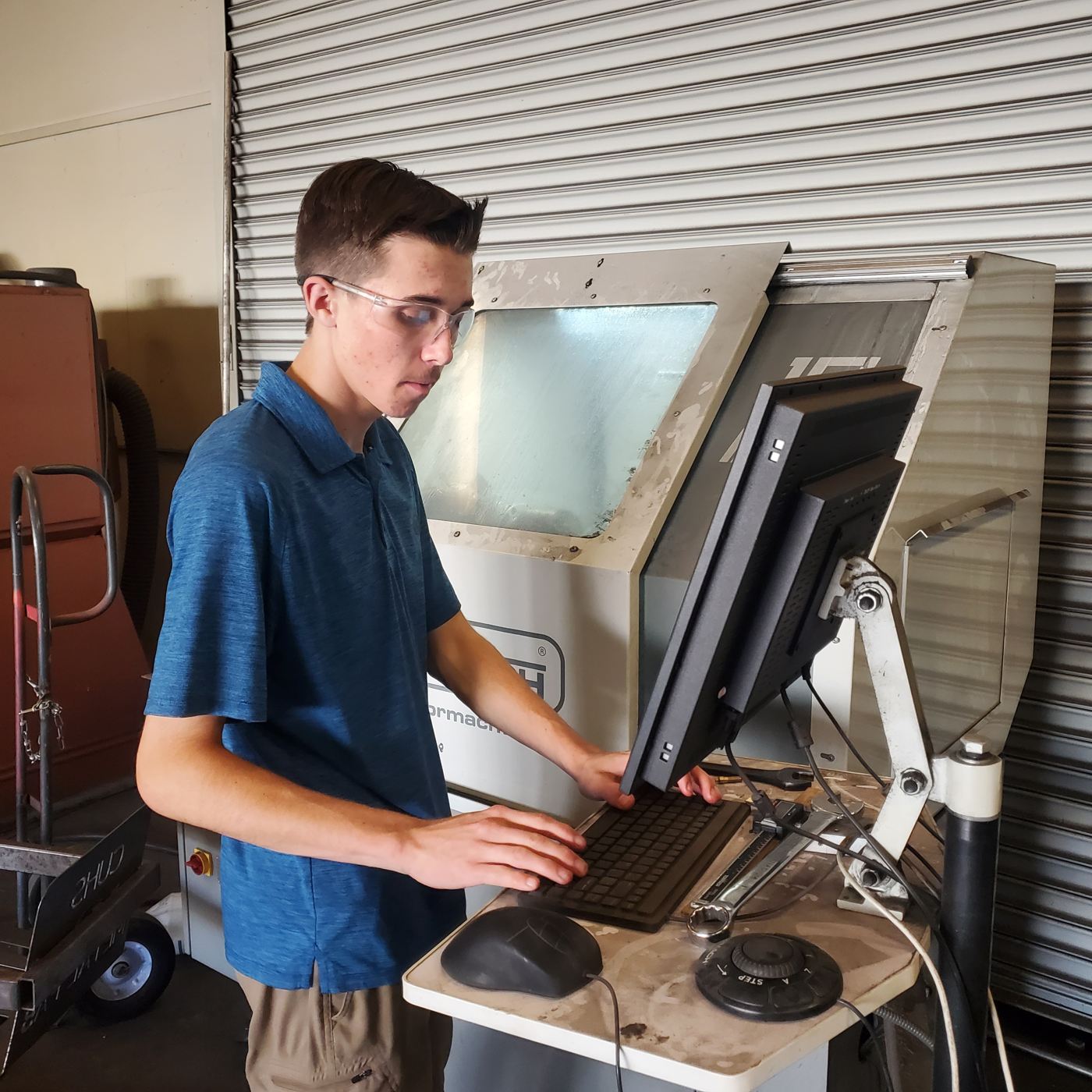 A student runs a CNC program from a shop computer